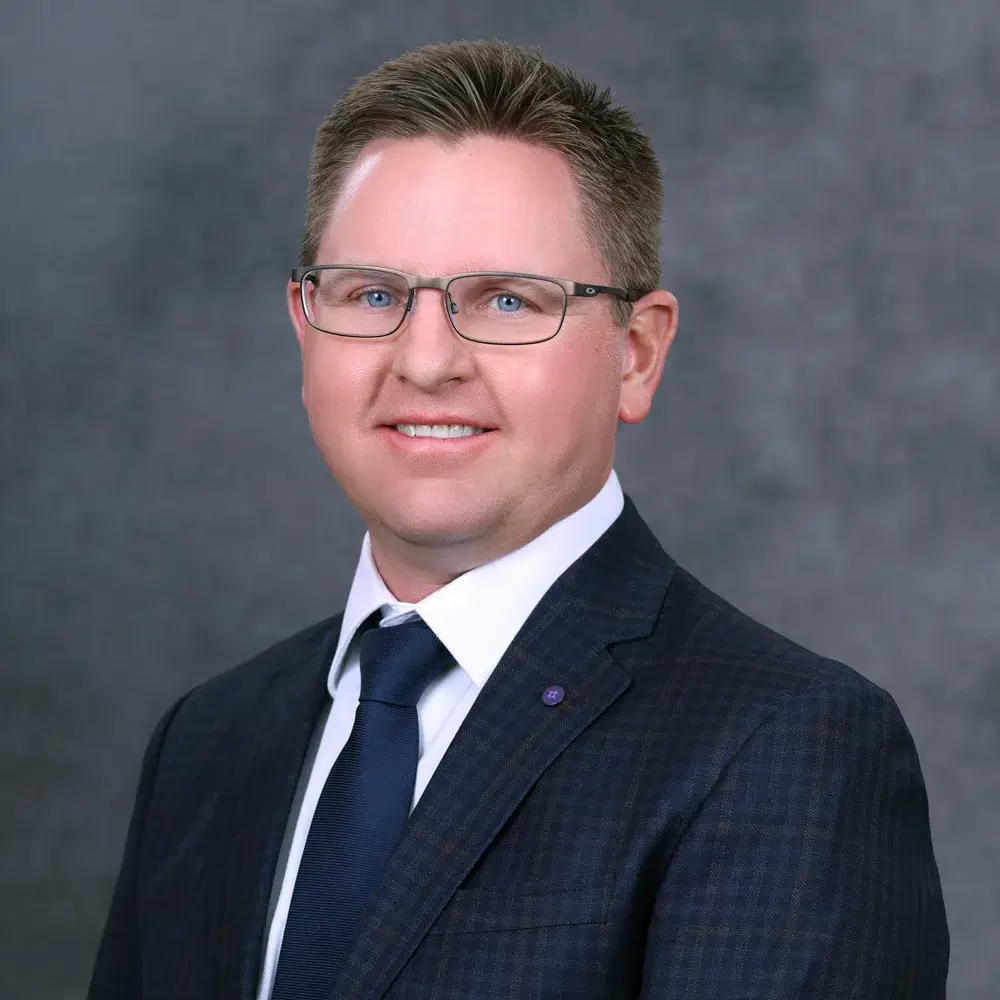 man smiling, wearing a suit and tie
