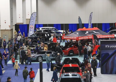 group of people in a large building at a car show