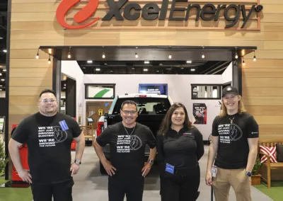 group of people at a tradeshow in front of a Xcel Energy sign