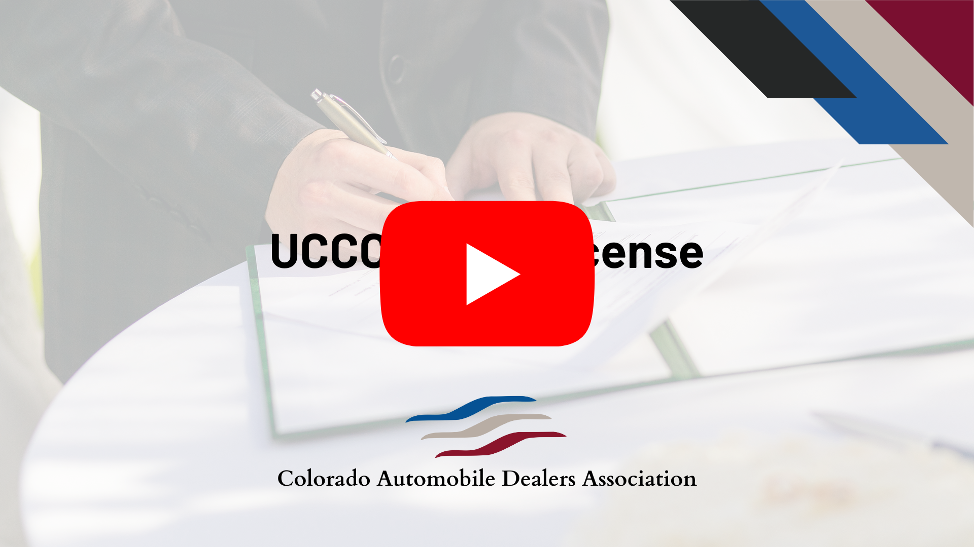 A person signs a document. Overlaid text reads "UCCC License." A red play button is at the center, suggesting a video. The Colorado Automobile Dealers Association logo and name are at the bottom. Various colored shapes are at the image's top right corner.